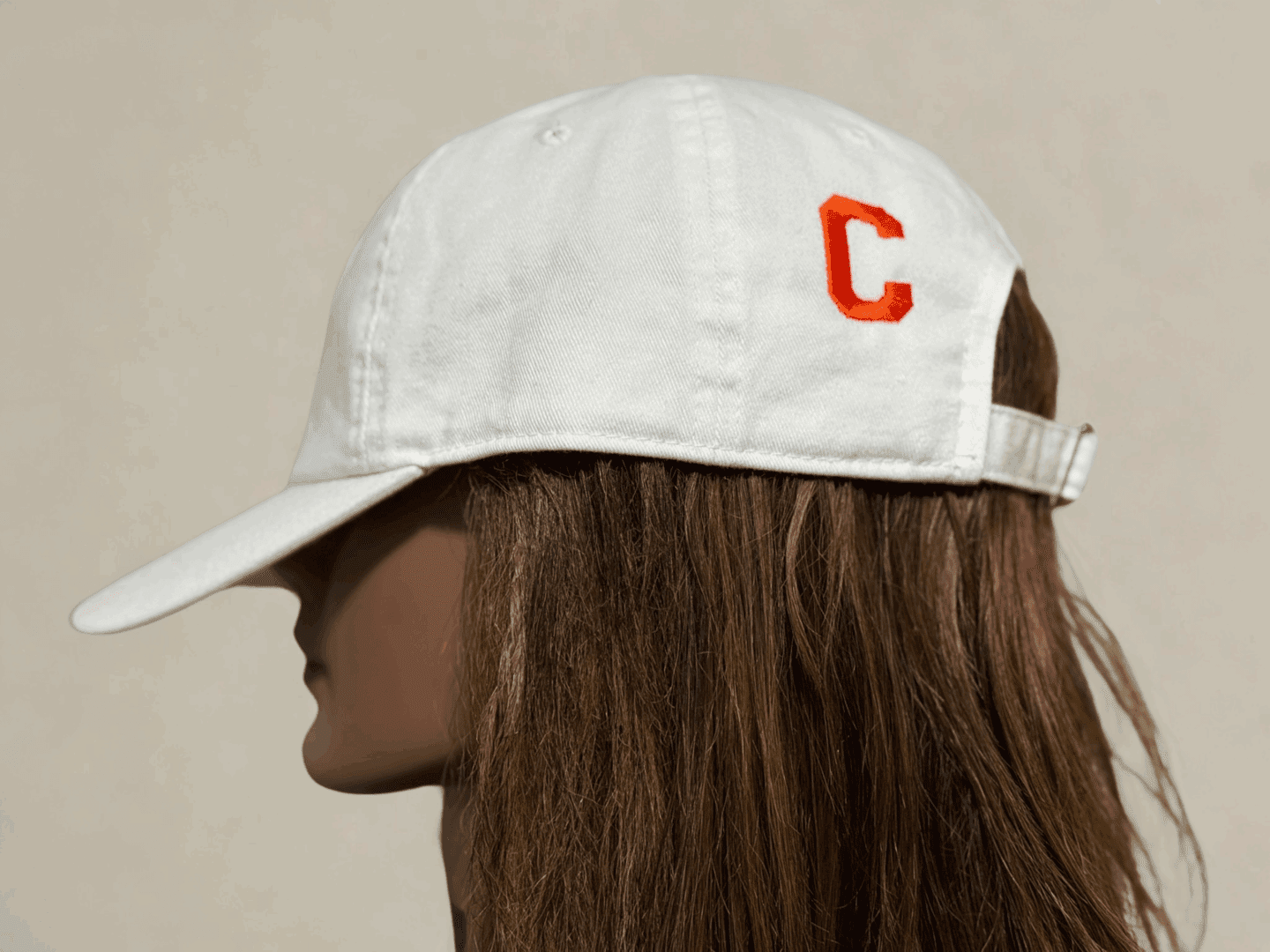 A woman with long hair wearing a baseball cap.