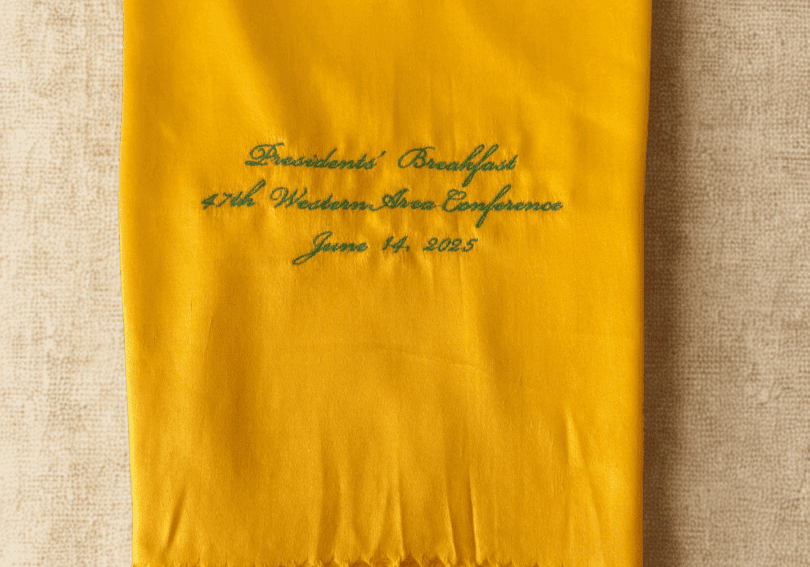 A yellow scarf with the name of president and date.