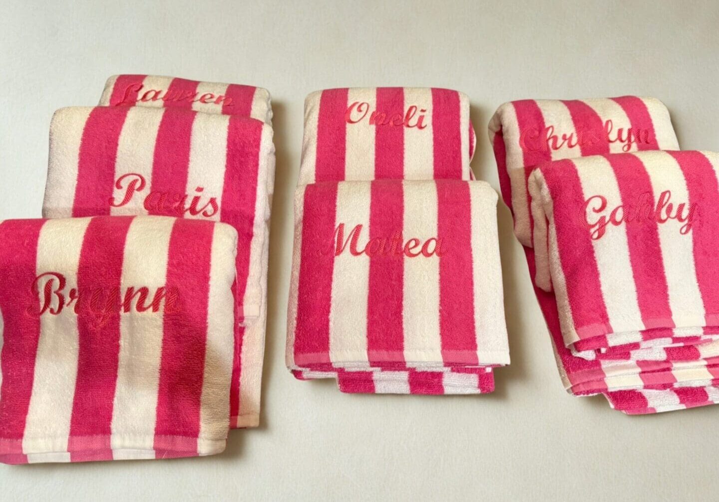 Stacked monogrammed pink and white beach towels
